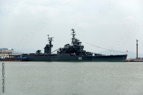 Novorossiysk, Russia - 18 August 2024 Cruiser Mikhail Kutuzov and dolphins, Black Sea, port, Krasnodar Territory, Novorossiysk. photo