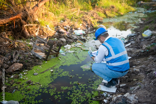 Water resource experts check the water quality in a community canal contaminated with garbage in the canal.