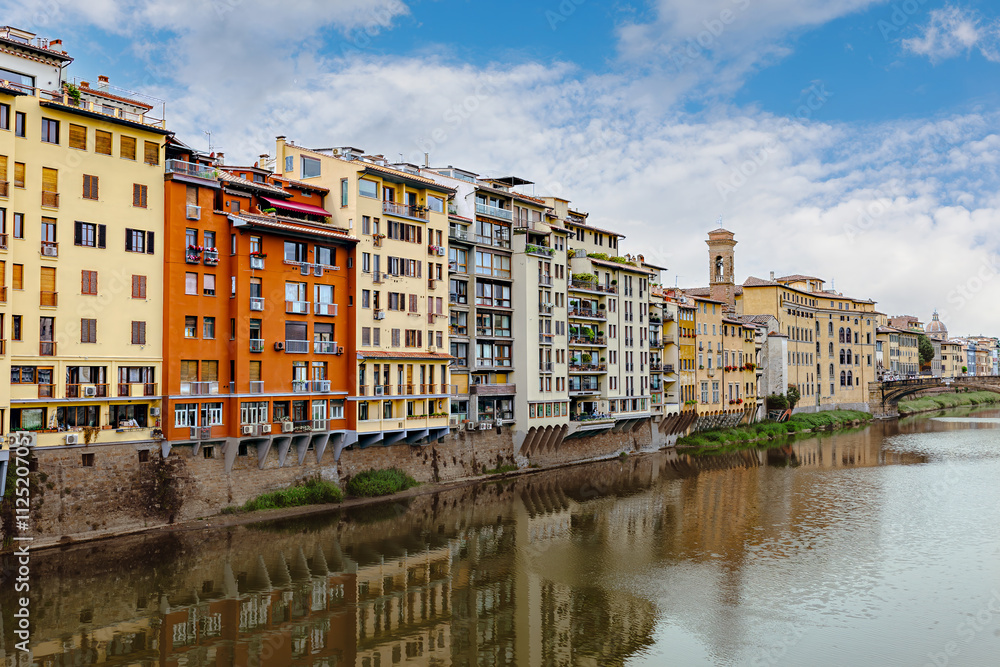 Colorful buildings reflect on the Arno River, showcasing Florence's rich history and stunning architecture. Visitors can enjoy the serene views along the waterfront. Colorful buildings reflect on the Arno River, showcasing Florence's rich history and stunning architecture. Visitors can enjoy the serene views along the waterfront.