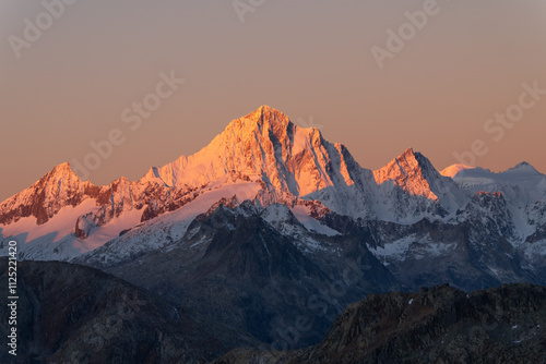 snowy peaks of rocky mountains in the red light of dawn