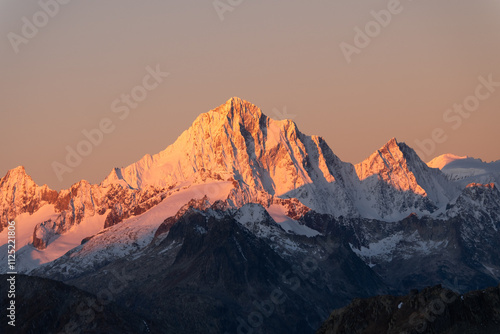 snowy peaks of rocky mountains in the red light of dawn