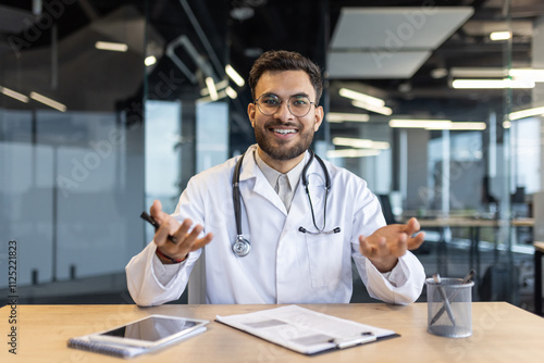 A smiling doctor in a white lab coat is engaging in a video call from an office. The scene conveys professionalism and the use of technology in modern healthcare communication.