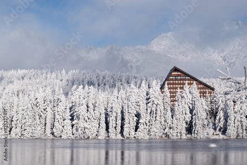 beautiful snowland scenery with hotel, lake and snowy trees in winter wonder fairytale photo