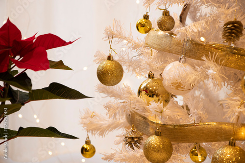 Golden Christmas balls, hung on the white Christmas tree, with white lights. Christmas postcard