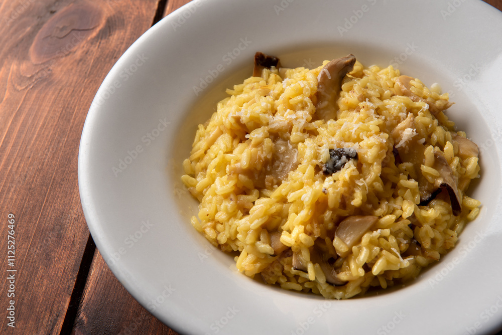 Delizioso risotto con zafferano e funghi, cibo vegetariano italiano Delizioso risotto con zafferano e funghi, cibo vegetariano italiano