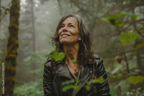 Portrait of a happy woman in her 50s sporting a classic leather jacket over backdrop of a mystical forest