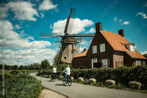 couple cycling by the windmill, Nigtevecht, Village in the Netherlands
