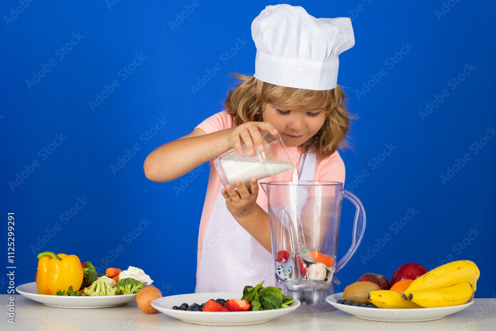 Portrait of a 7, 8 years old child in cook cap and apron making milk shake smoothie and cooking food in kitchen. Cute little blonde happy smiling chef. Portrait of a 7, 8 years old child in cook cap and apron making milk shake smoothie and cooking food in kitchen. Cute little blonde happy smiling chef.