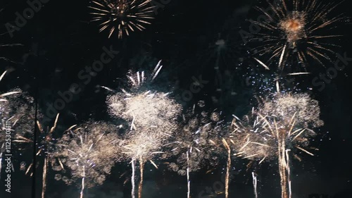 Spectacular fireworks illuminating the night sky during New Year's Eve celebration, symbolizing joy, global festivity, and the technical artistry of pyrotechnics with hints of danger and excitement photo