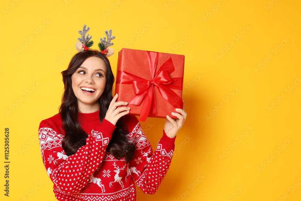 Happy woman with Christmas gift on yellow background Happy woman with Christmas gift on yellow background