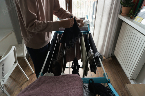 Person Hanging Clothes Indoors