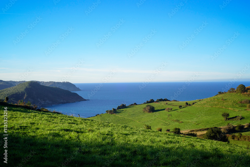 Monte de laderas verdes junto a mar en Asturias