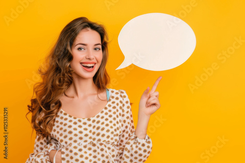 Cheerful woman in a hat holding a blank speech bubble against a vibrant yellow background, ready for your text. photo