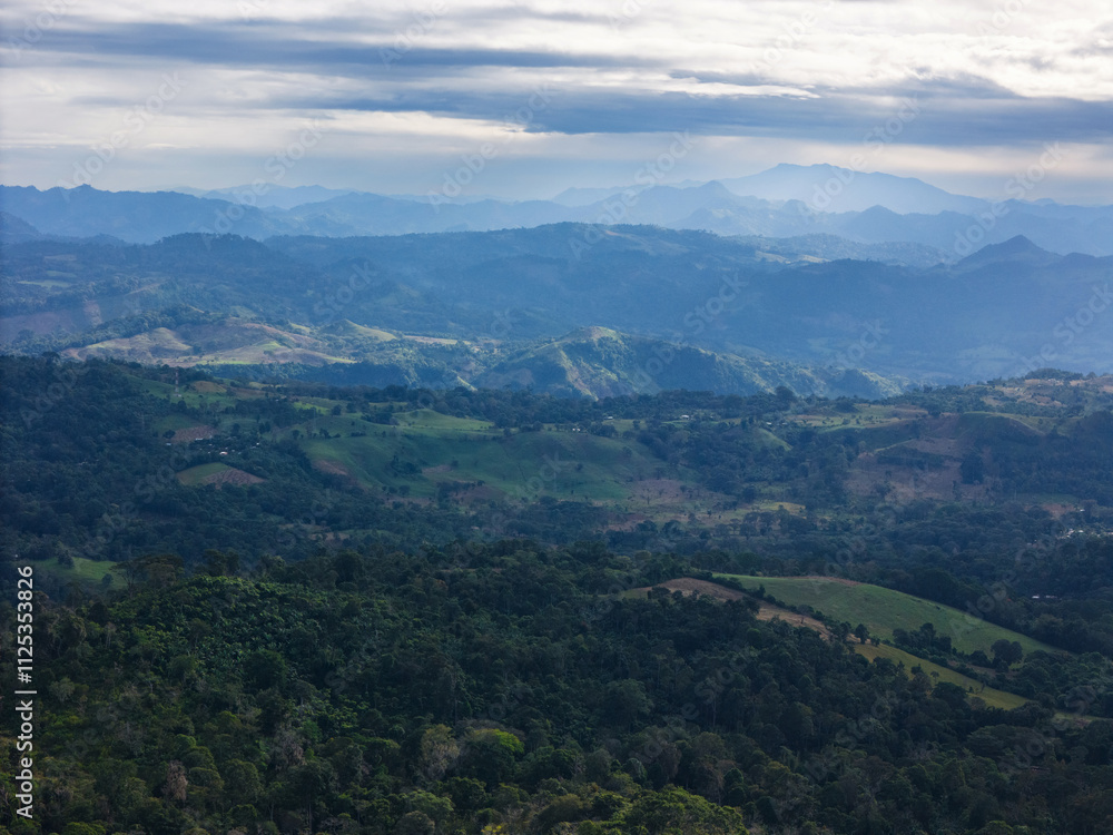 Green hills with jungle forest with grey sky aerial drone view Green hills with jungle forest with grey sky aerial drone view