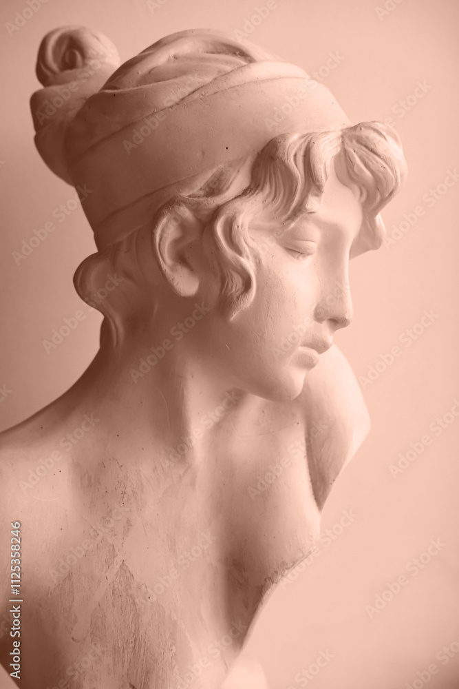 Female plaster bust. Side view, vertical image. Color of the Year Mocha Mousse. Female plaster bust. Side view, vertical image. Color of the Year Mocha Mousse.
