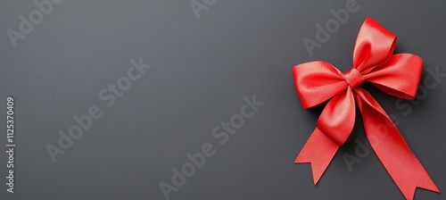 A Merry Christmas gift card with a red ribbon bow on a black, glossy, colorful background, offering blank copy space on a vibrant texture template.