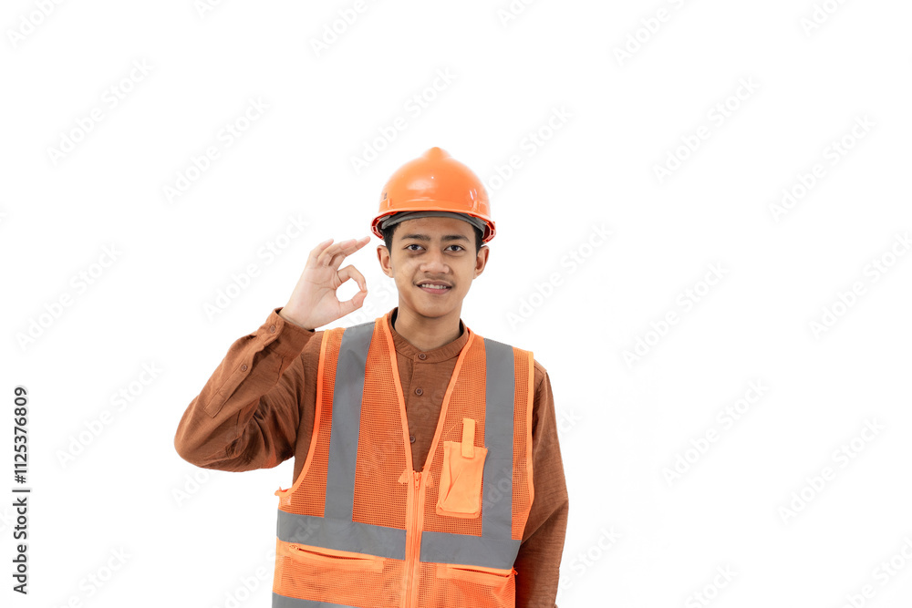 Young Indonesian male construction worker in full safety gear doing ok gesture while looking at camera, industrial and construction concept, isolated on white background. Young Indonesian male construction worker in full safety gear doing ok gesture while looking at camera, industrial and construction concept, isolated on white background.