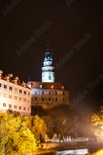 Obraz na płótnie A stunning night view of the illuminated tower of Cesky Krumlov Castle towering above the Vltava River, creating a magical atmosphere with the reflection in the water w salonie
