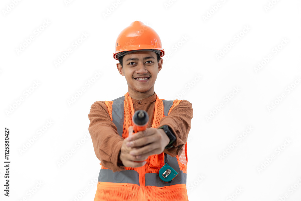 Young Indonesian male construction worker in full safety gear posing using drill, construction and industry concept, isolated on white background. Young Indonesian male construction worker in full safety gear posing using drill, construction and industry concept, isolated on white background.
