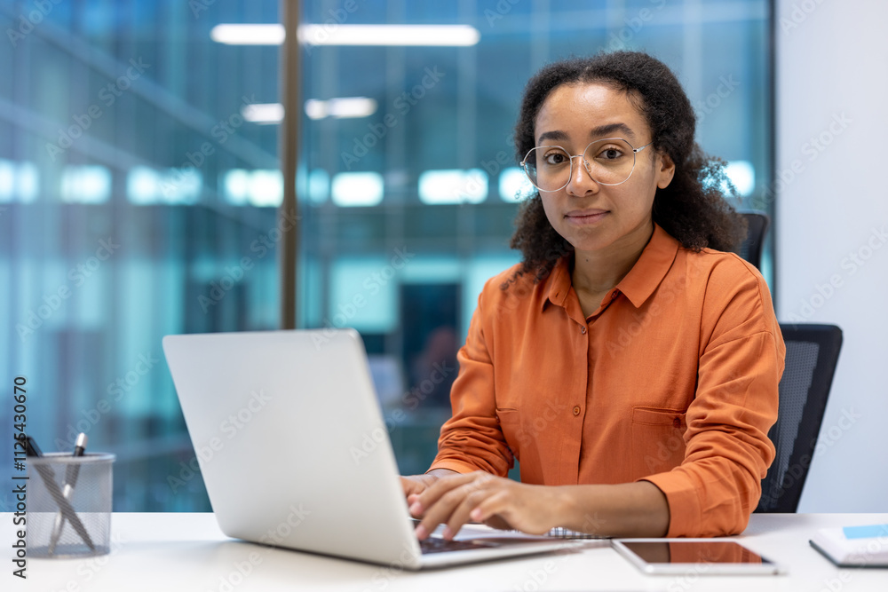 A young professional woman confidently working at her laptop in a modern office. She is focused and engaged, wearing a smart casual outfit. This image captures the essence of productivity A young professional woman confidently working at her laptop in a modern office. She is focused and engaged, wearing a smart casual outfit. This image captures the essence of productivity