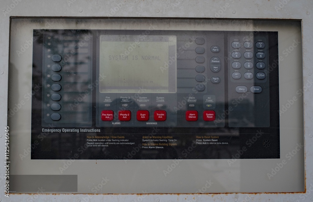 The fire alarm panel is attached to a concrete wall. The fire alarm panel is attached to a concrete wall.