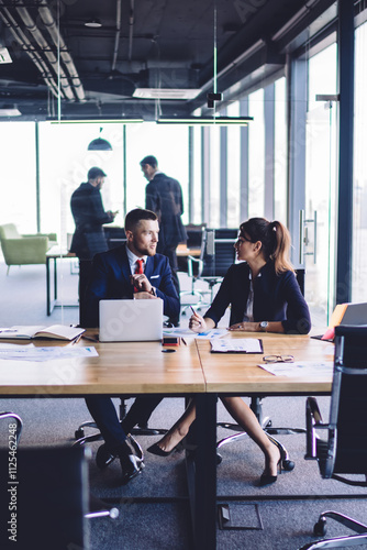 Confident male and female colleagues analyzing information during cooperation working process, formally dressed executive managers communicating about report during together business experience