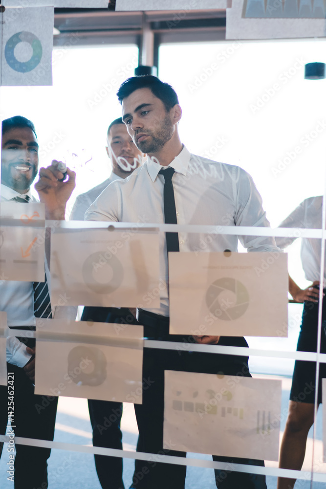 © BullRun - Successful proud ceo writing market planning on modern glass board during conference meeting for briefing with experienced employees, group of cheerful partners collaborating on infographics revenue © BullRun - Successful proud ceo writing market planning on modern glass board during conference meeting for briefing with experienced employees, group of cheerful partners collaborating on infographics revenue