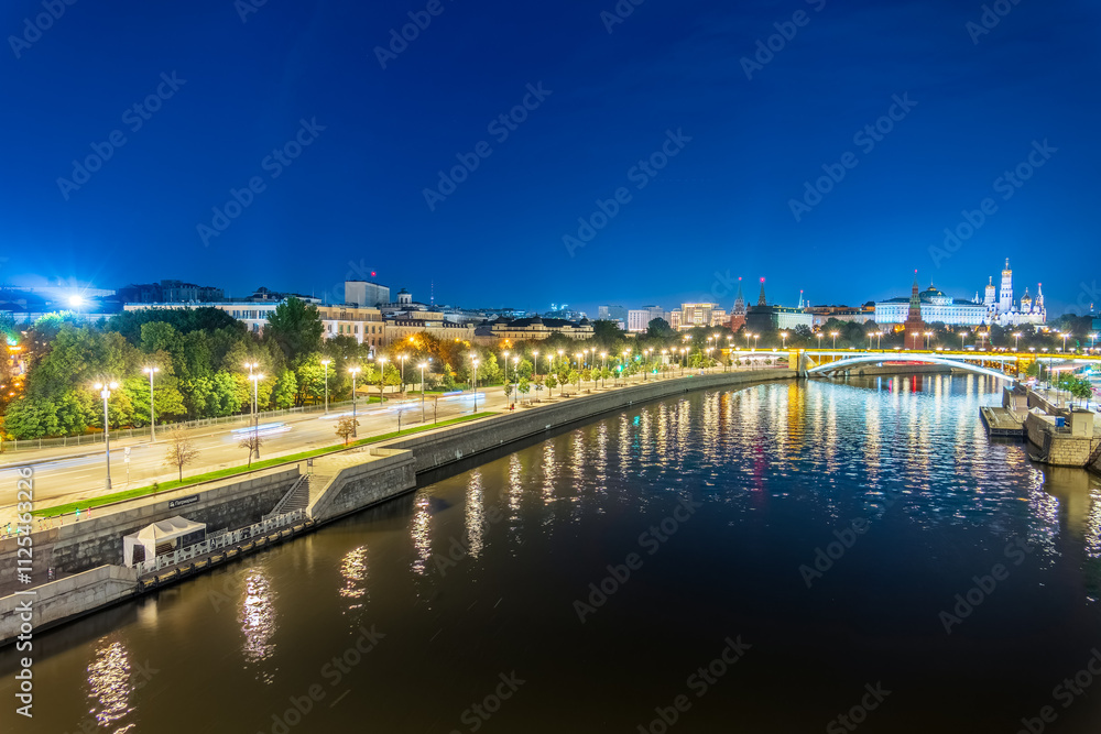 Fototapeta premium Illuminated Moscow Kremlin and Bolshoy Kamenny Bridge at summer night. View from the Patriarshy pedestrian Bridge