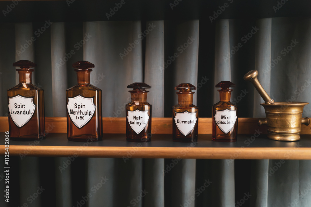 There are several small old pharmacy bottles on a shelf