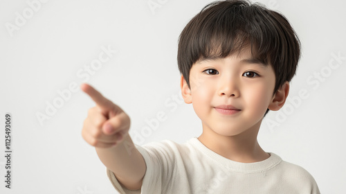 young boy with dark hair is pointing forward