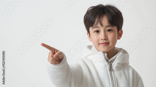 young boy in a white jacket is pointing to the right