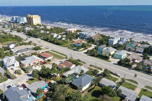 Aerial looking east over New Smyrna Beach, Florida neighborhoods, beachfront houses and the Atlantic Ocean.