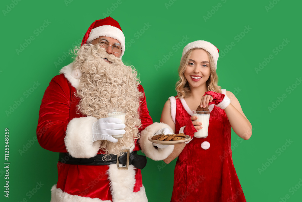 Santa Claus and beautiful young woman eating tasty cookies with milk on green background Santa Claus and beautiful young woman eating tasty cookies with milk on green background