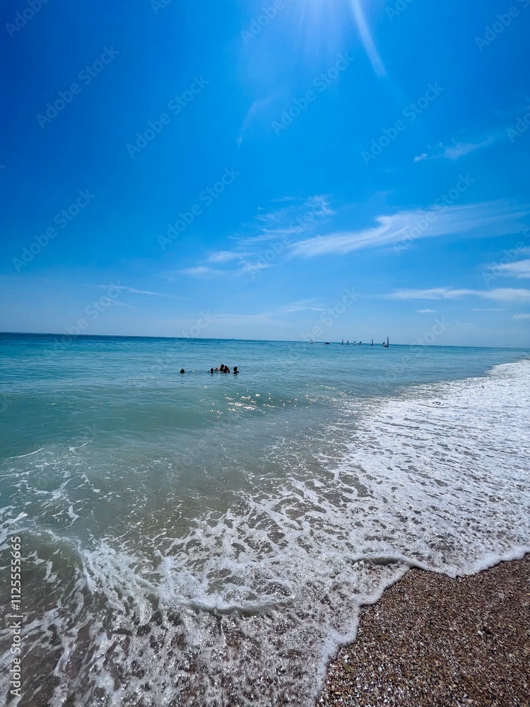 Fototapeta premium Serene beach day with clear blue skies and gentle waves. Porto Sant'Elpidio, Italy.