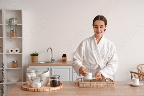 Young woman in bathrobe put...