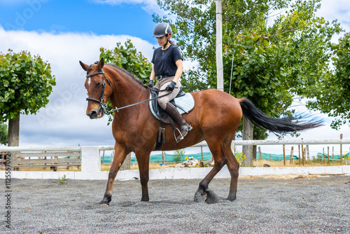 girl leaning forward while riding brown horse photo