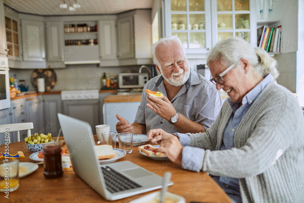 Happy senior couple enjoying breakfast together in a cozy kitchen Happy senior couple enjoying breakfast together in a cozy kitchen