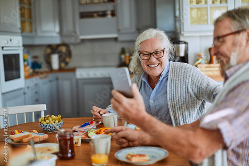 Wallpaper Mural Happy senior couple enjoying breakfast together in a cozy kitchen Torontodigital.ca