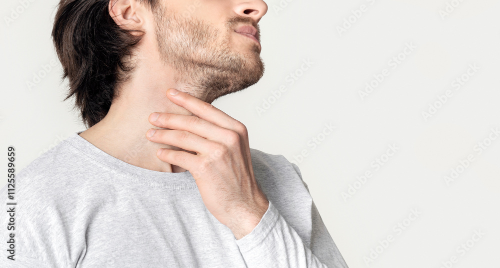 Man with throat sore is holding aching spot, cropped, panorama Man with throat sore is holding aching spot, cropped, panorama
