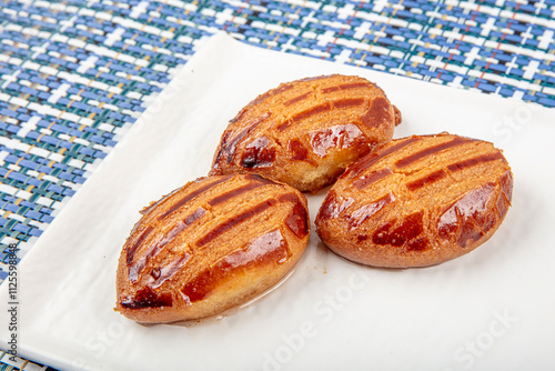 Traditional Turkish Dessert with Tea: Sekerpare. Sekerpare is served with tea on a white plate. photo