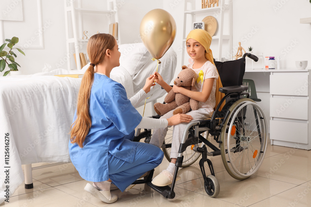 Little girl after chemotherapy in wheelchair taking golden balloon from nurse at hospital. Childhood cancer awareness concept Little girl after chemotherapy in wheelchair taking golden balloon from nurse at hospital. Childhood cancer awareness concept