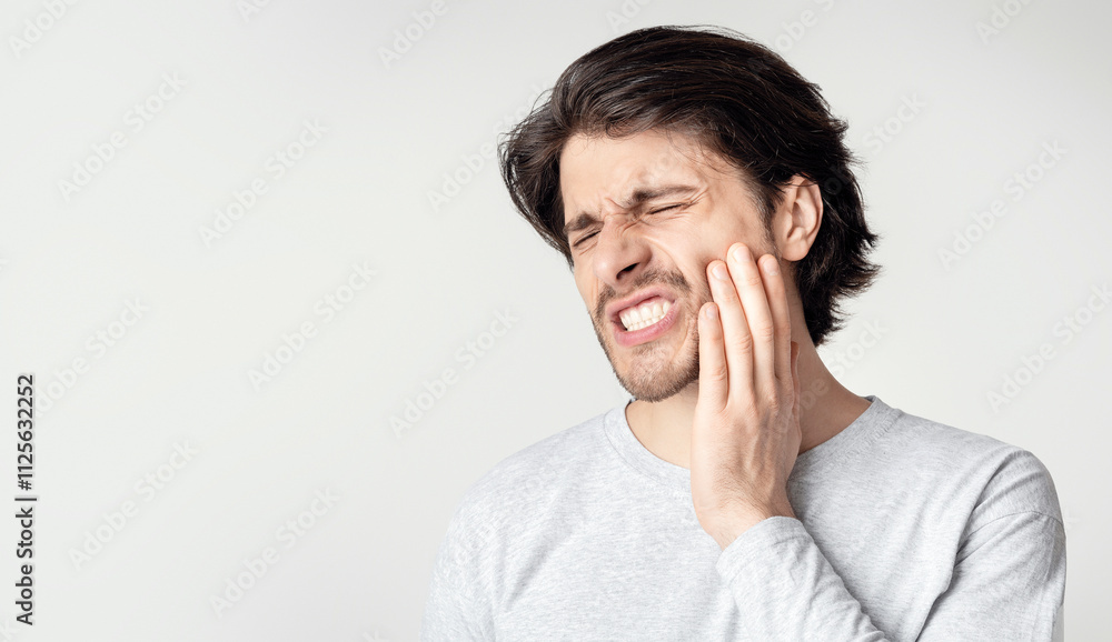 Young man suffering from terrible strong teeth pain Young man suffering from terrible strong teeth pain