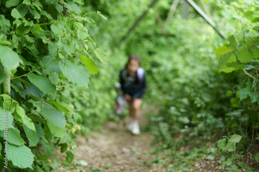little cute girl in glasses with backpack travels in summer in forest. Concept of active healthy sporty child little cute girl in glasses with backpack travels in summer in forest. Concept of active healthy sporty child