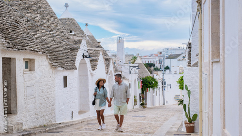Fotografia Couple strolling hand-in-hand through the charming streets of Puglia, Italy on a