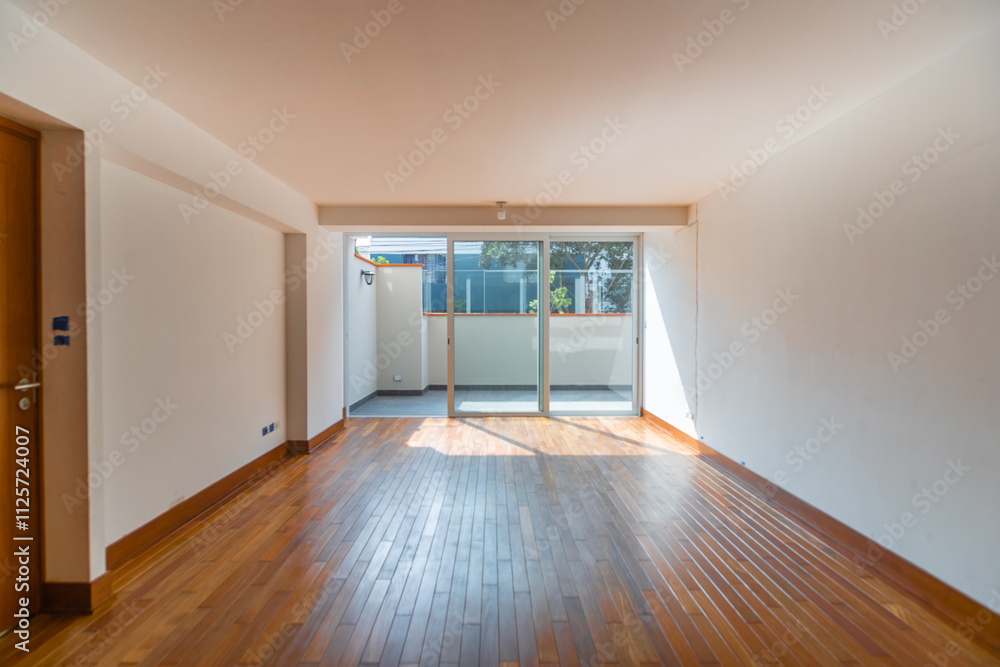 Obraz premium Sala de departamento con piso de melamina, con mampara y vista a patio iluminado