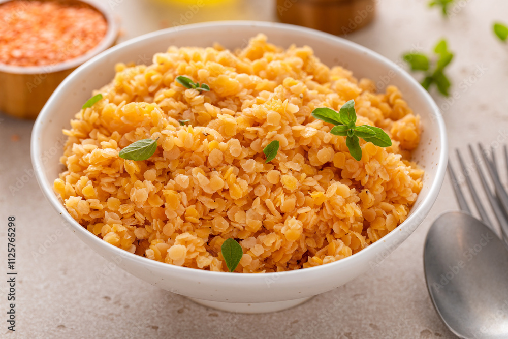 Cooked red lentils in a bowl, vegan protein source Cooked red lentils in a bowl, vegan protein source