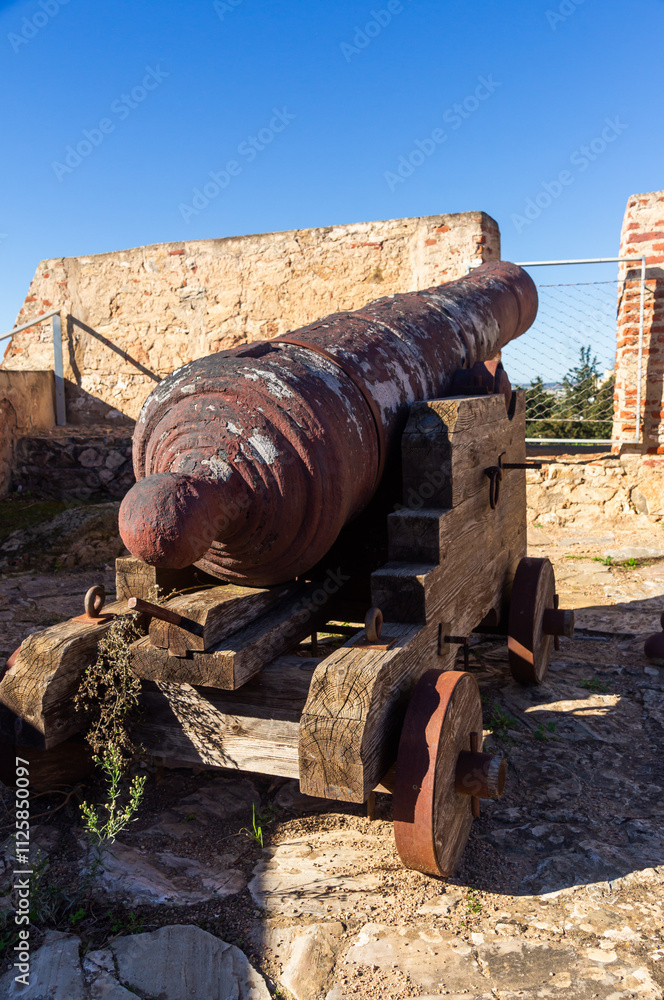 Ancient cannon next to an embrasure in the wall of a 17th-century bastioned fort. Fort of San Cristóbal, Badajoz, Spain. Ancient cannon next to an embrasure in the wall of a 17th-century bastioned fort. Fort of San Cristóbal, Badajoz, Spain.