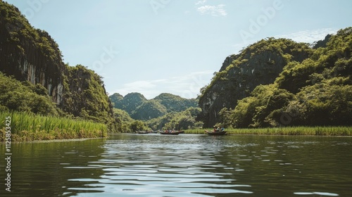 Scenic beauty of Tam Coc with towering limestone peaks, lush green rice paddies, and boats floating down the quiet river under a clear sky