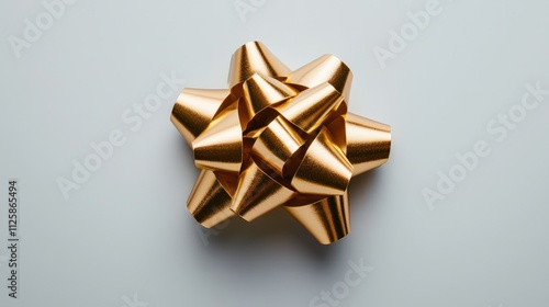 A shiny gold gift bow placed on white.