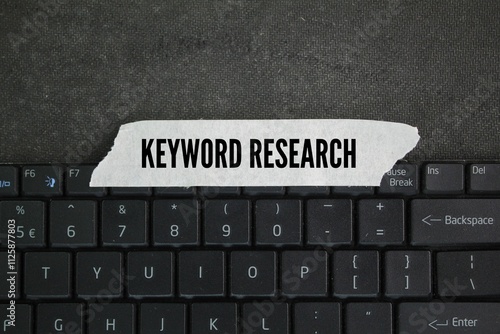 Valokuva laptop keyboard and sticker with the word keyword research